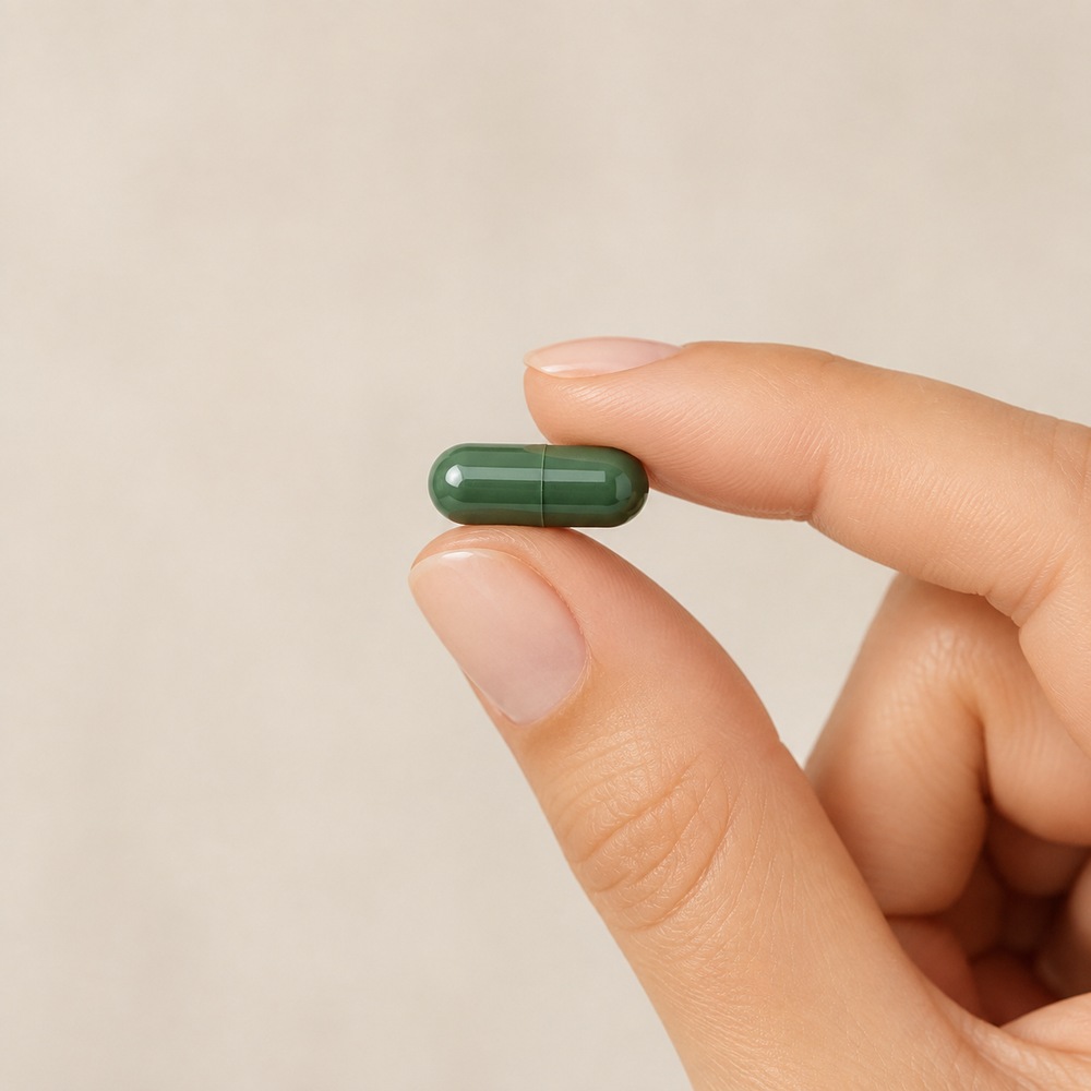 A single FlatFeams capsule held between two fingers