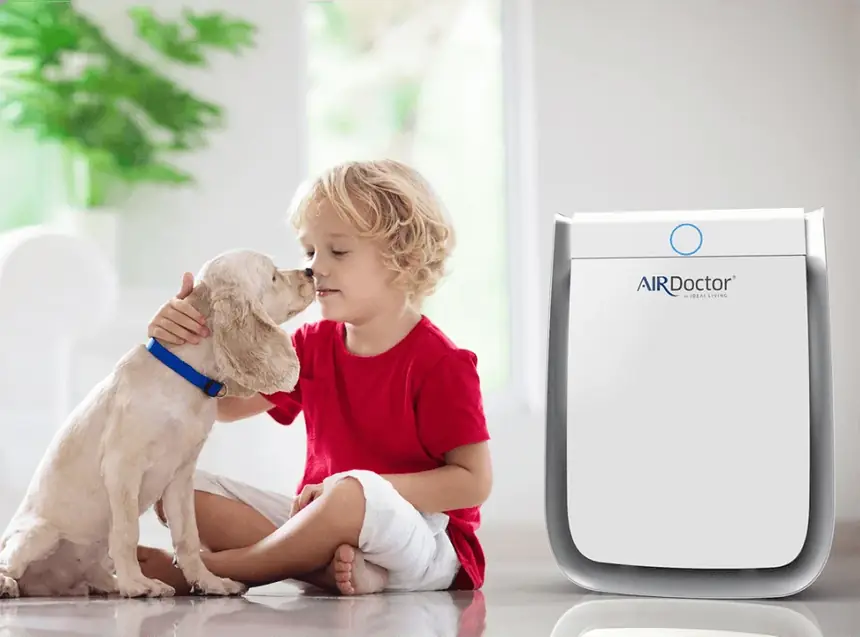 Child with a dog beside an AirDoctor air purifier