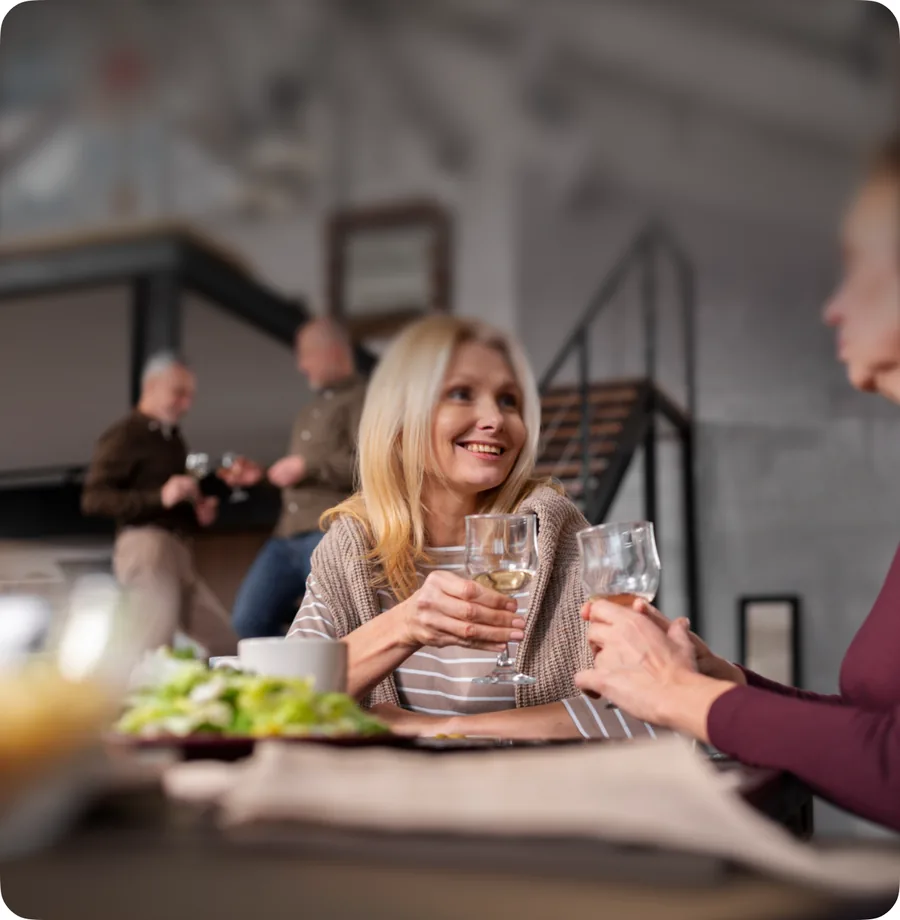 Two people laughing across a restaurant table at dinner