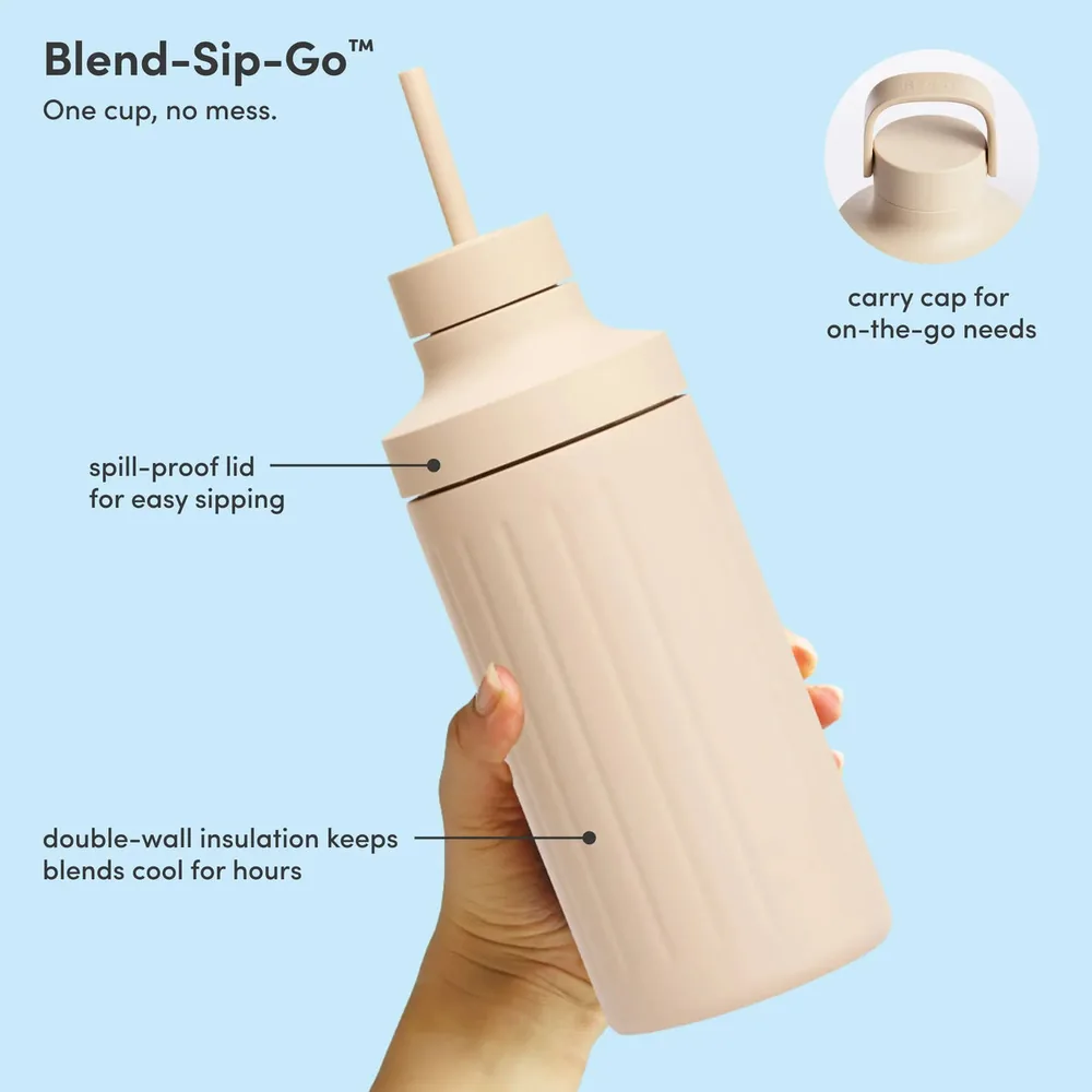 A hand holding a Beast blending vessel fitted with a spill proof drinking lid, annotated with the carry cap and the double wall insulation