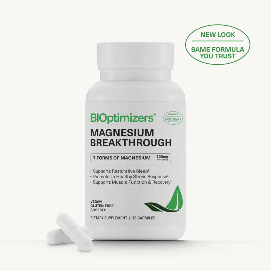 A BIOptimizers Magnesium Breakthrough bottle in its current packaging, marked seven forms of magnesium, beside two capsules