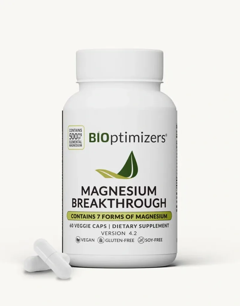 A white BIOptimizers Magnesium Breakthrough bottle photographed beside two loose capsules