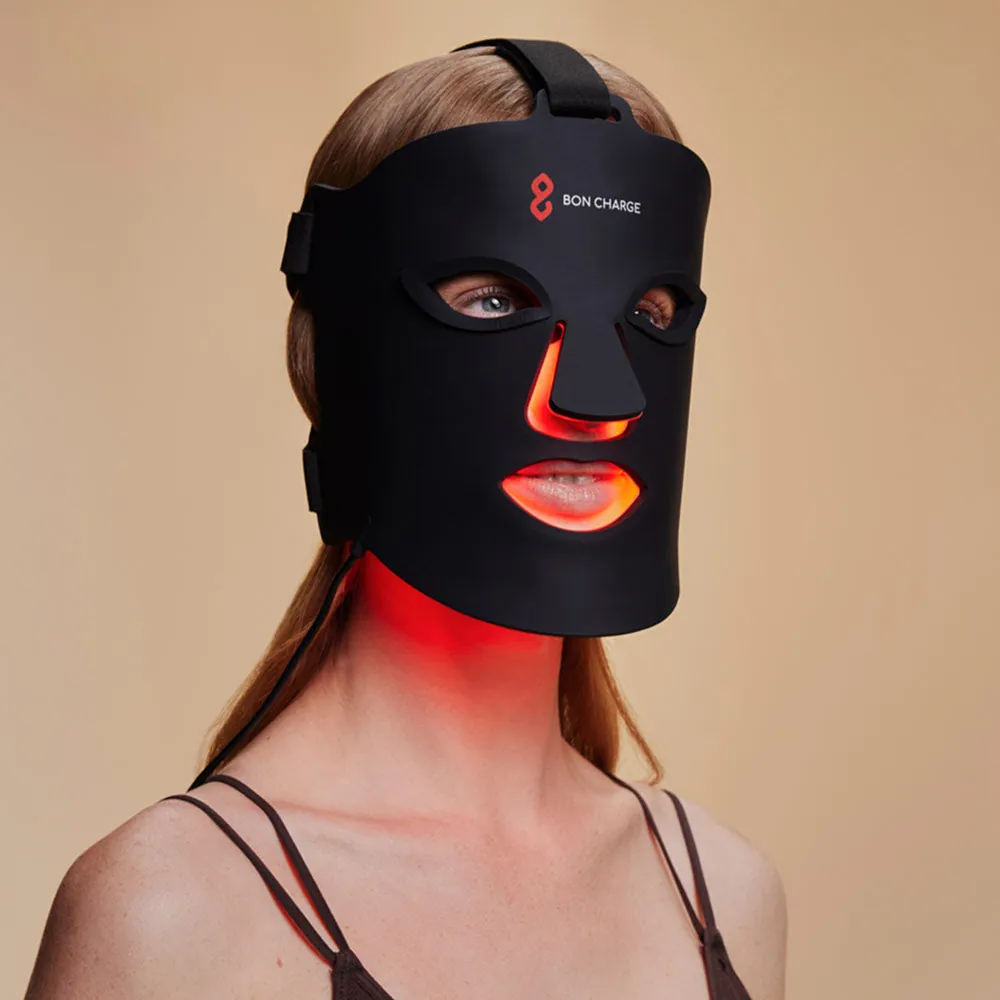 A woman wearing the BON CHARGE Red Light Face Mask during a session