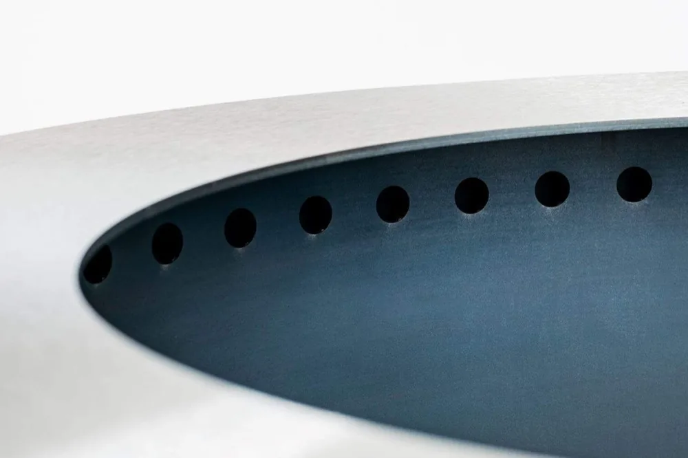 Close view of the ring of small holes drilled just under the rim of a Breeo X Series fire pit