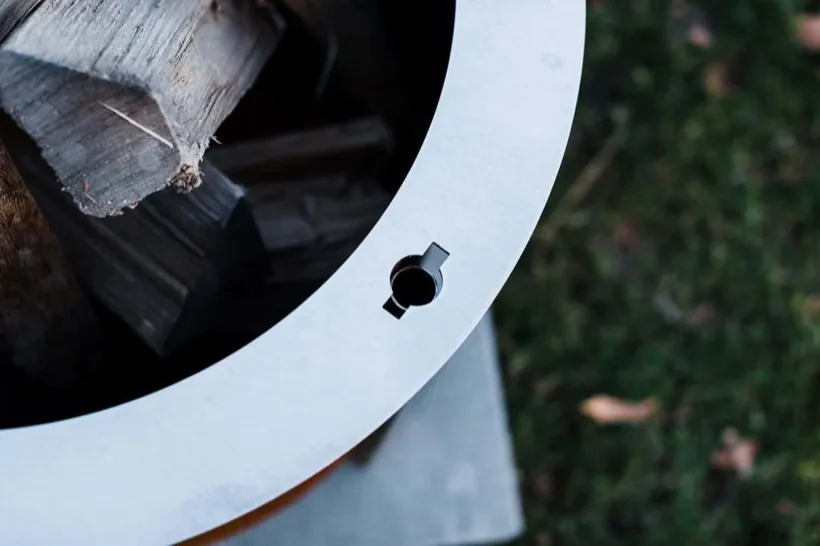 Close view of the slot in the rim of a Breeo fire pit that accepts the Outpost grill post