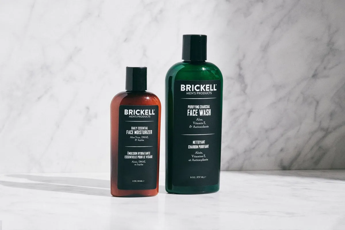 Brickell Daily Essential Face Moisturizer beside the Purifying Charcoal Face Wash on a marble surface