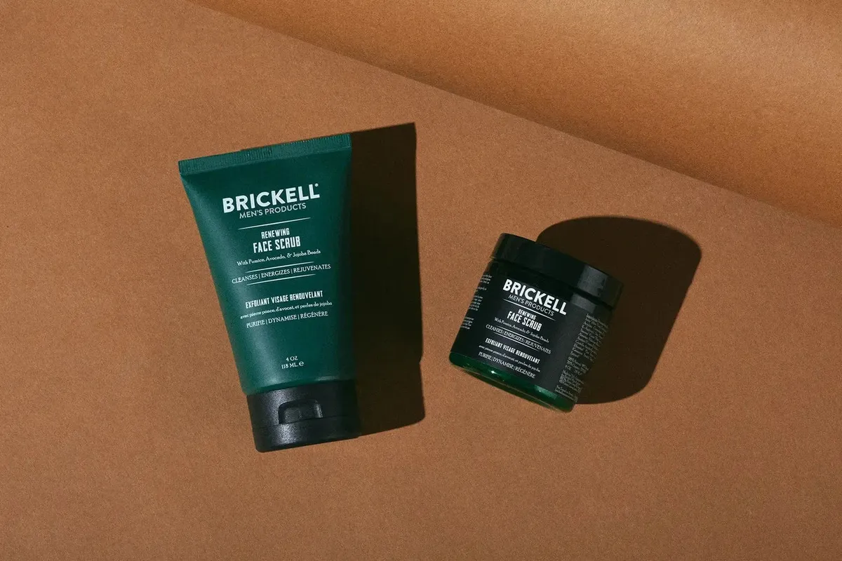 Brickell Renewing Face Scrub tube and jar photographed on a terracotta background
