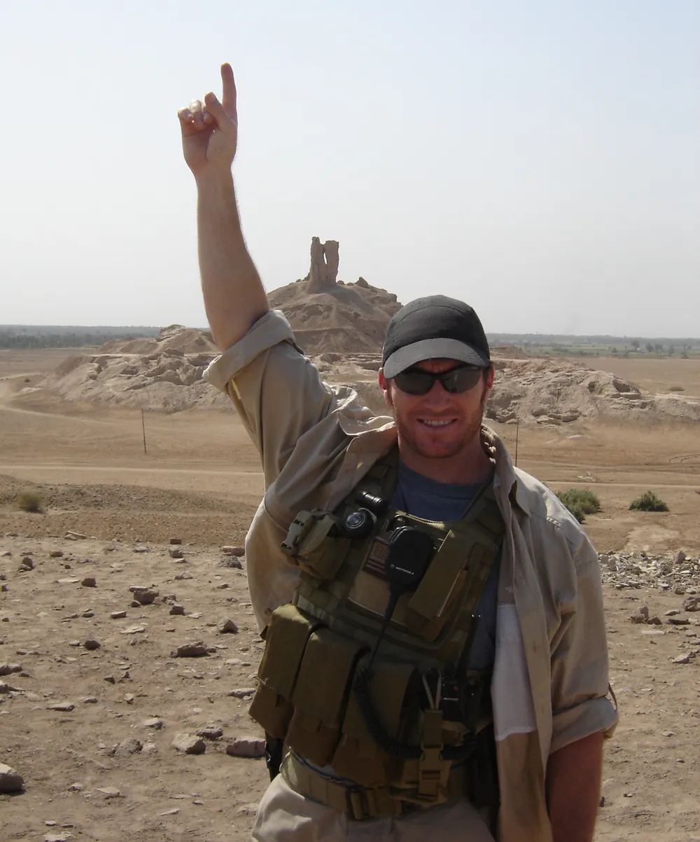 A man in the field in desert terrain, raising one arm, from the BUBS Naturals brand story.