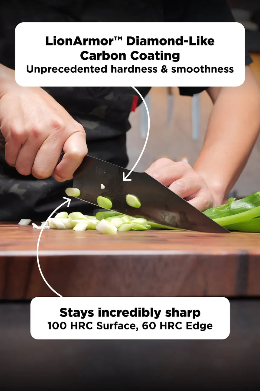 A cook slicing spring onions on a wooden board with the Spartan Ghost santoku