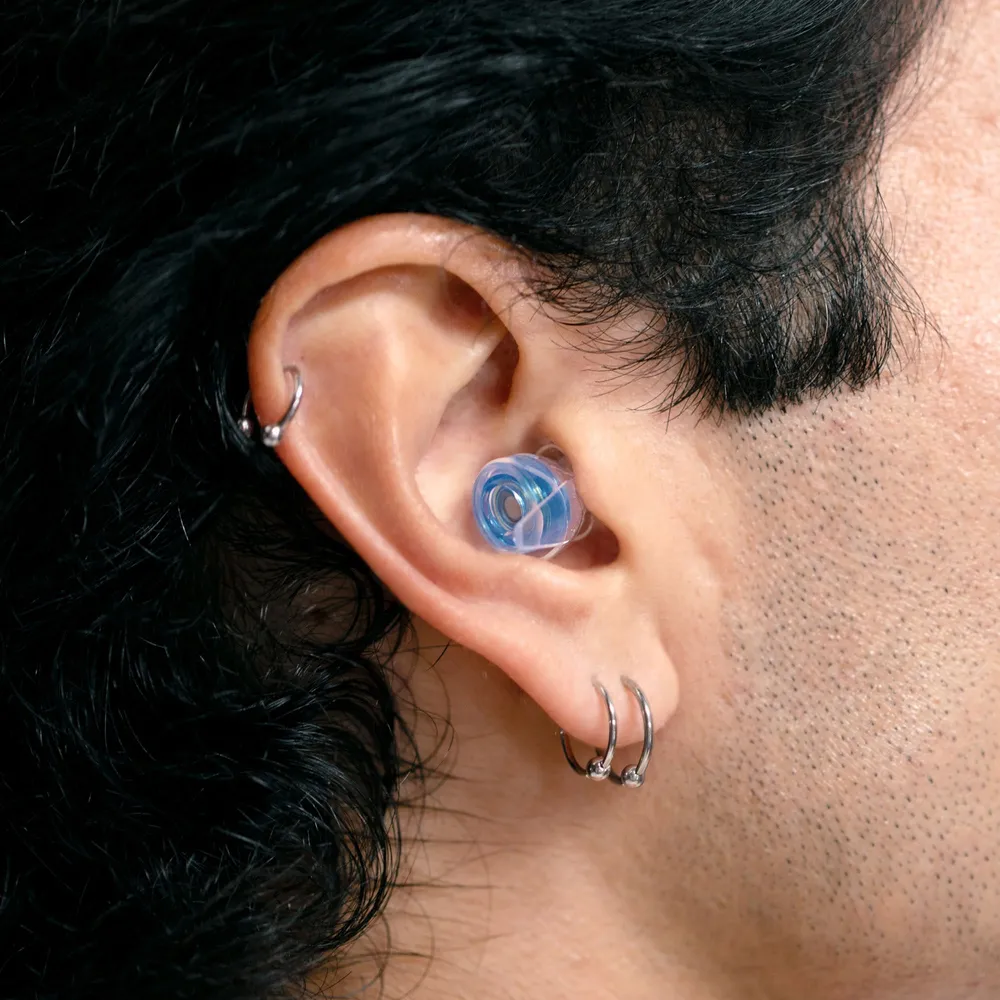 Close up of a blue high fidelity earplug seated in an ear
