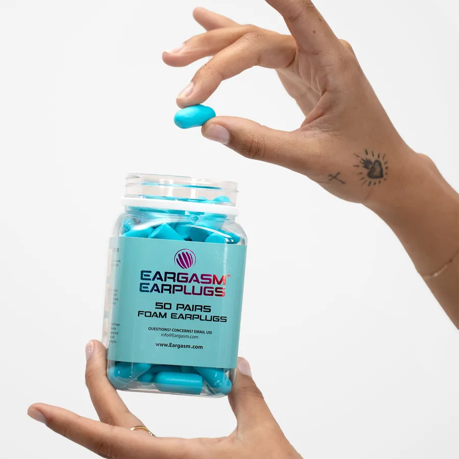 A jar of Eargasm foam earplugs held in one hand
