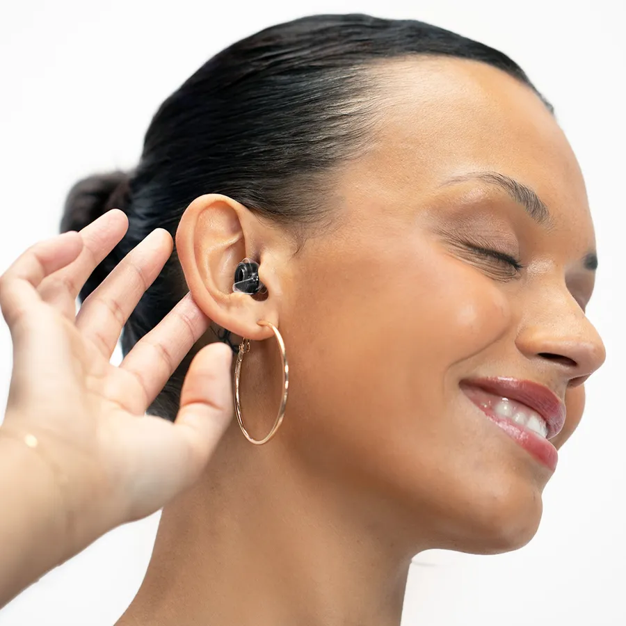 A model in profile wearing a black high fidelity earplug