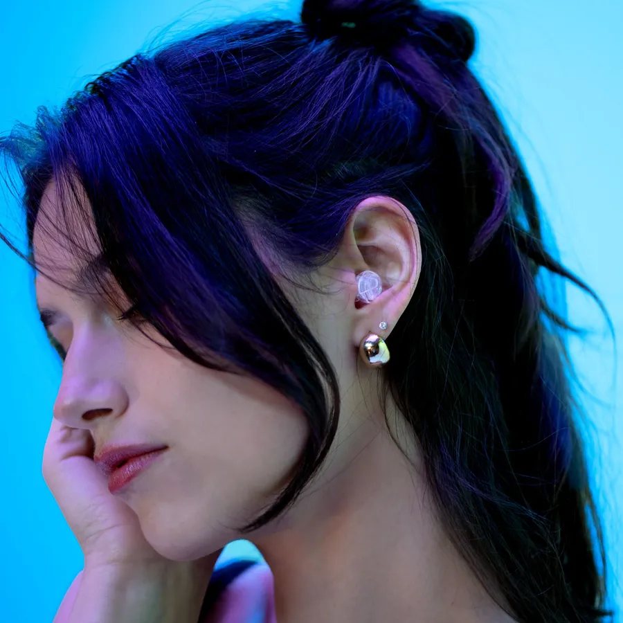 A woman wearing Eargasm All Nighters sleep earplugs