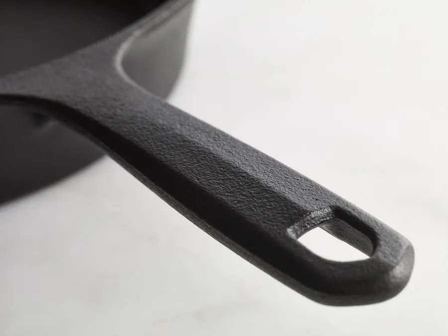 Close-up of a Field skillet handle showing the central ridge and the shield-shaped hanging hole