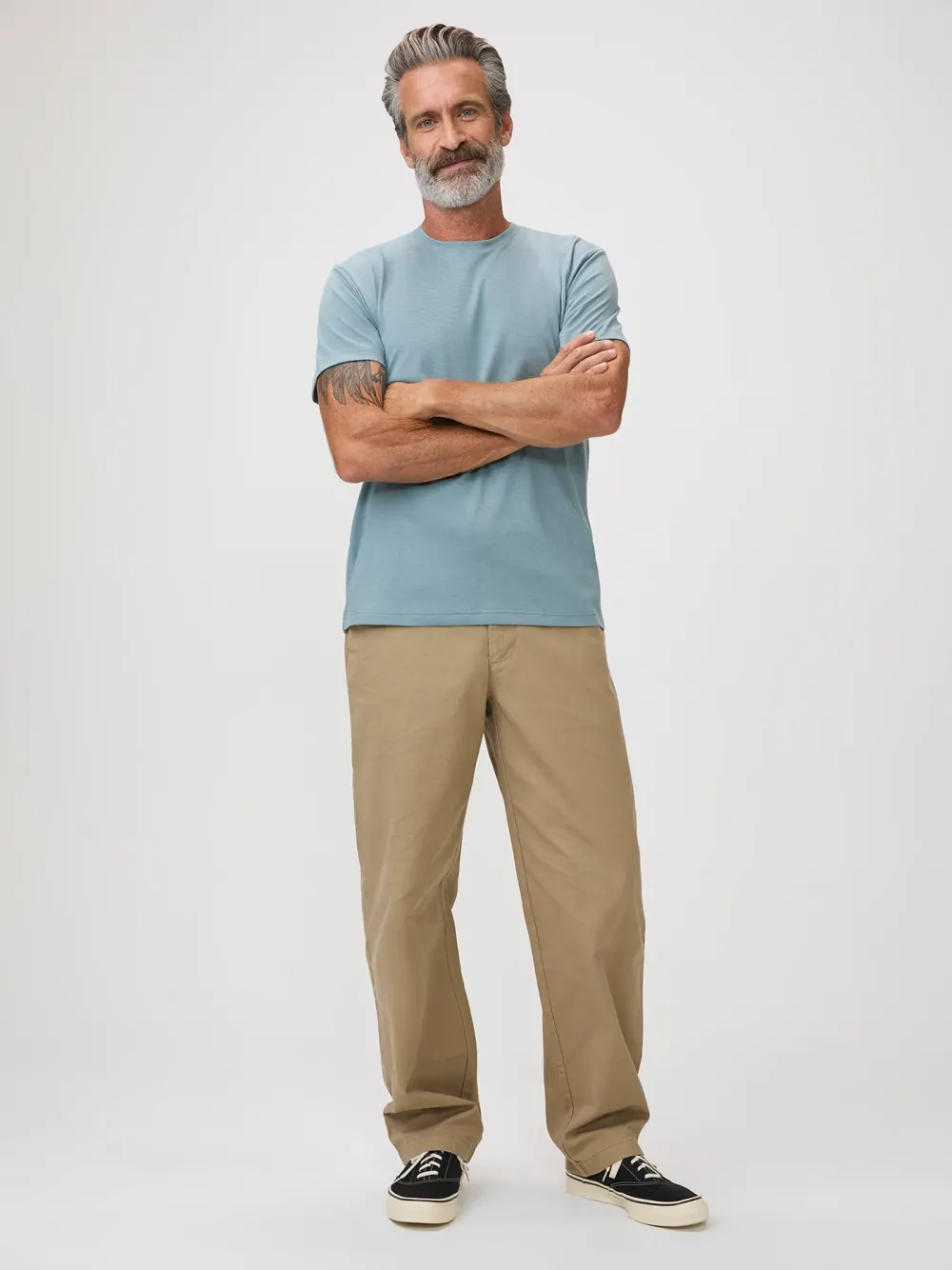 A man in a light grey Fresh Clean Threads crew neck tee, standing, photographed from the front.
