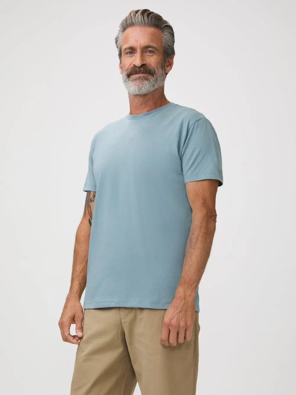Side view of a man wearing a light grey Fresh Clean Threads crew neck tee, showing how the body of the shirt drapes.