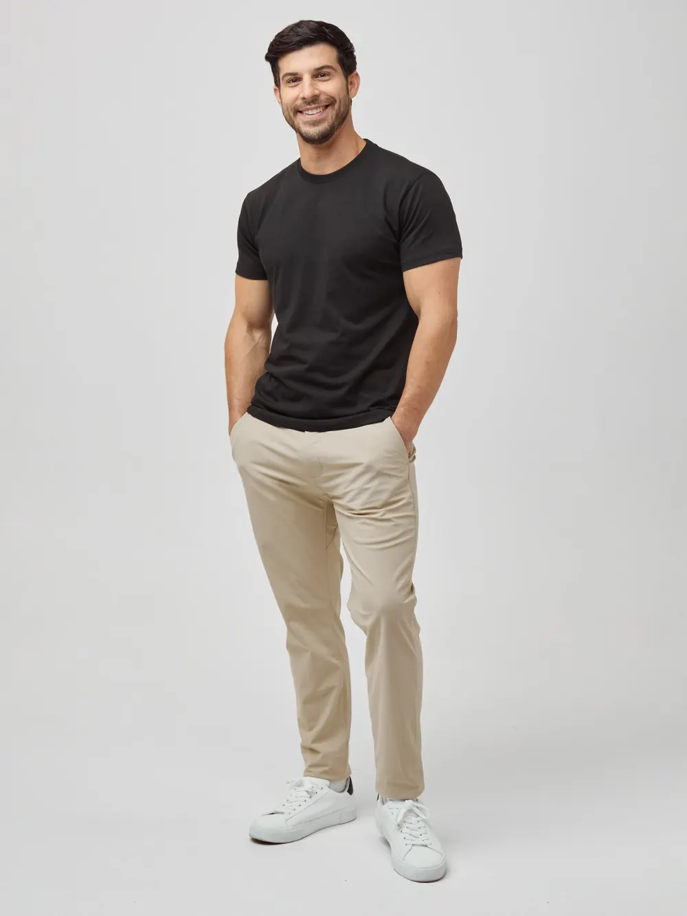 A man wearing a black Fresh Clean Threads crew neck tee, photographed full length.