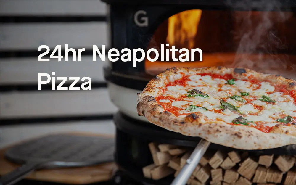 A Neapolitan pizza being lifted from the stone floor of a wood fired Gozney Dome.