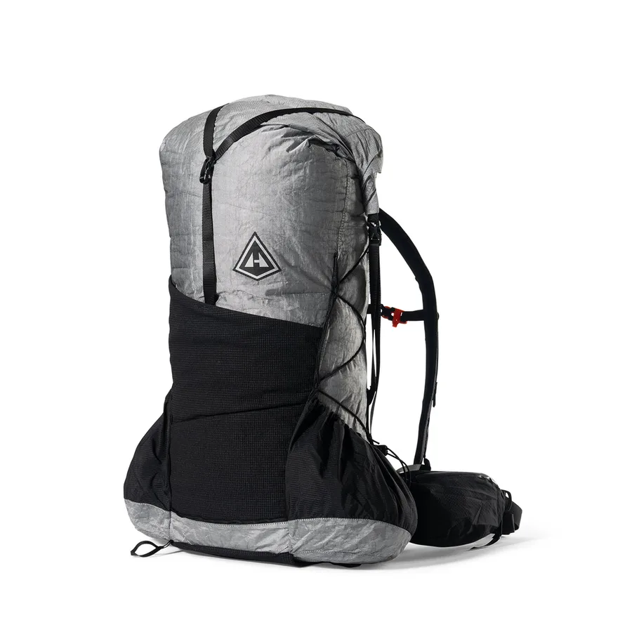 Grey and black Unbound backpack with a stretch front pocket, shown from the side.