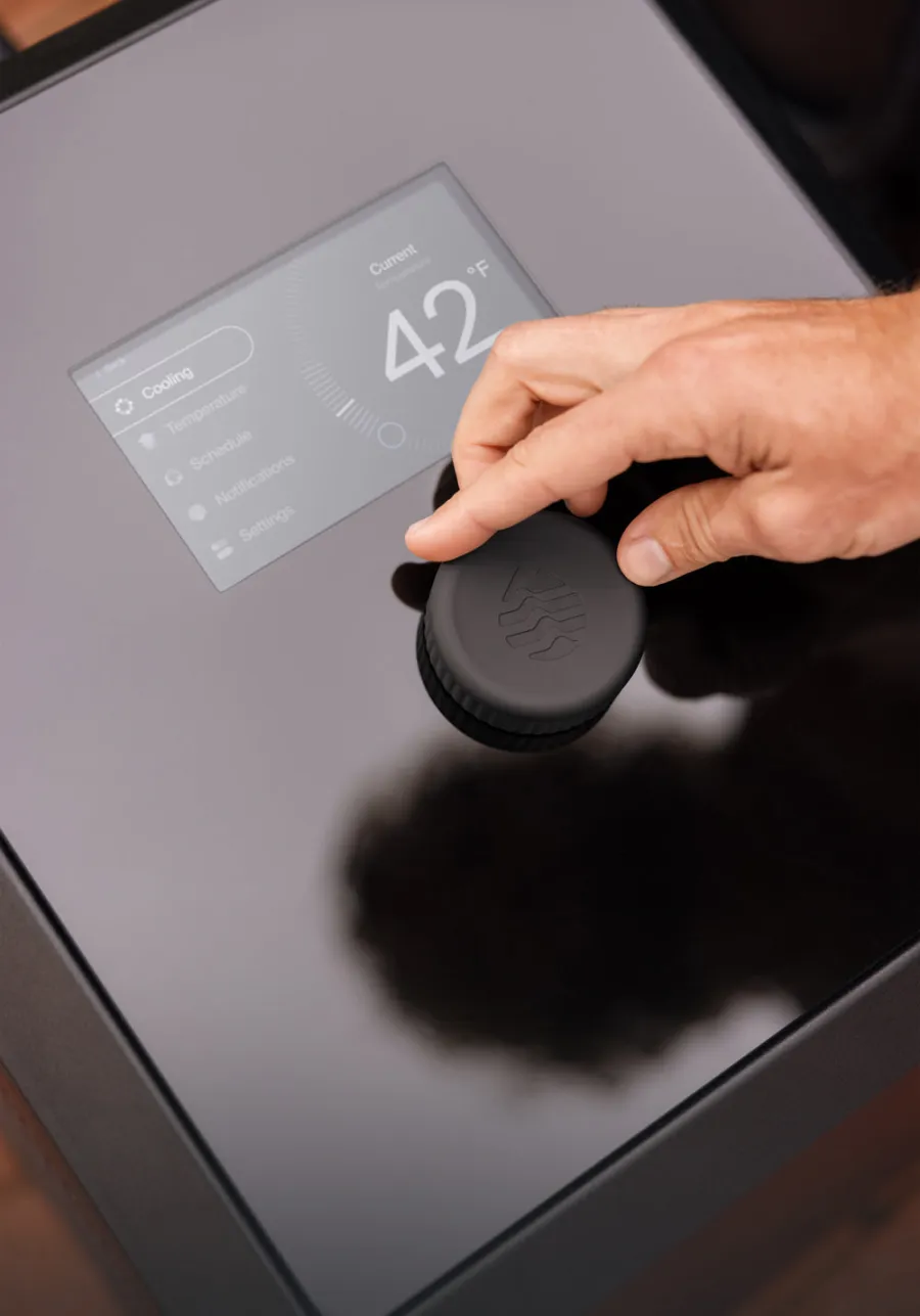 A hand adjusting the temperature dial on an Ice Barrel Chiller control panel showing 42
