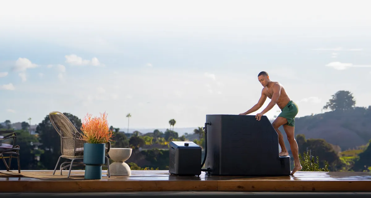 A man stepping into an Ice Barrel 500 outdoors on a terrace