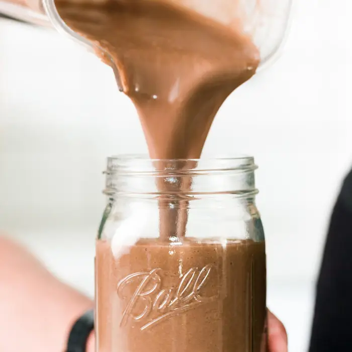 Chocolate shake being poured into a glass jar