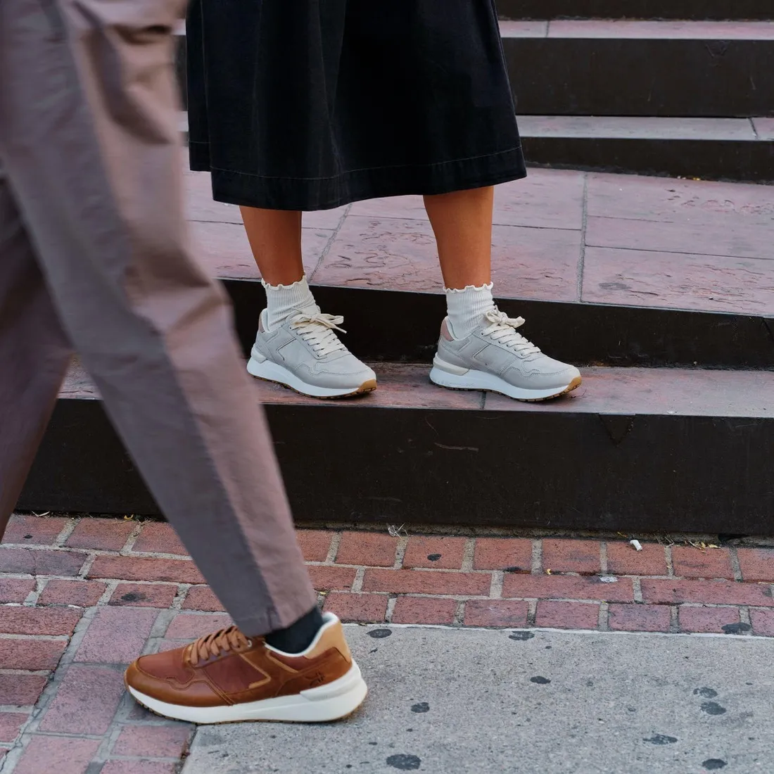 Two people walking on a city street wearing KURU APOGEE Luxe shoes