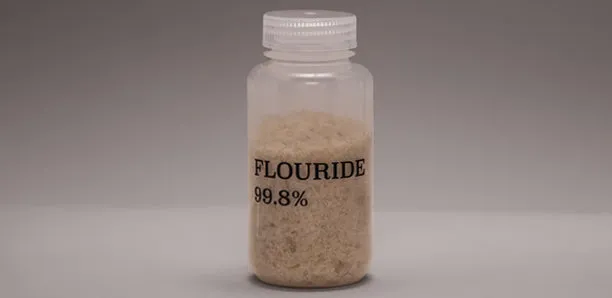 A laboratory jar labeled fluoride on a gray background.