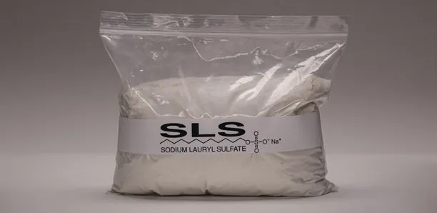 A clear bag of sodium lauryl sulfate powder on a gray background.