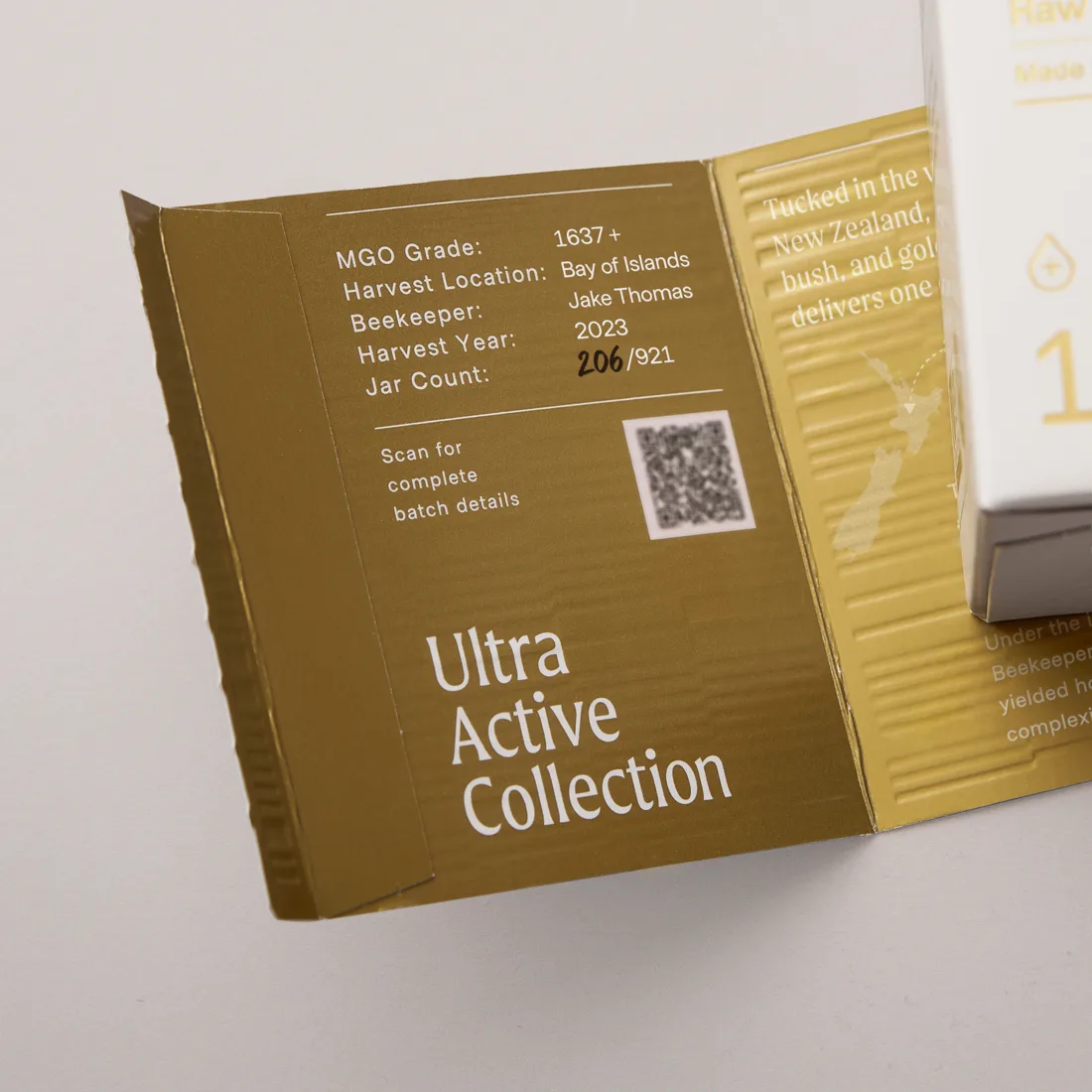 Inside panel of a Manukora box printed with MGO grade 1637 plus, harvest location Bay of Islands, beekeeper Jake Thomas, harvest year 2023, jar count 206 of 921, and a QR code