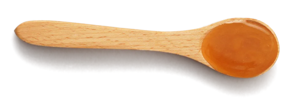 Wooden spoon holding a portion of amber Manuka honey
