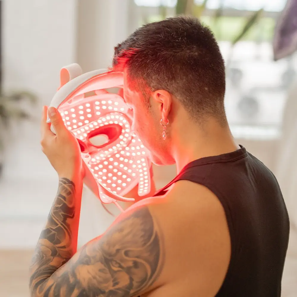 A man wearing the lit MitoGLOW mask, seen from behind