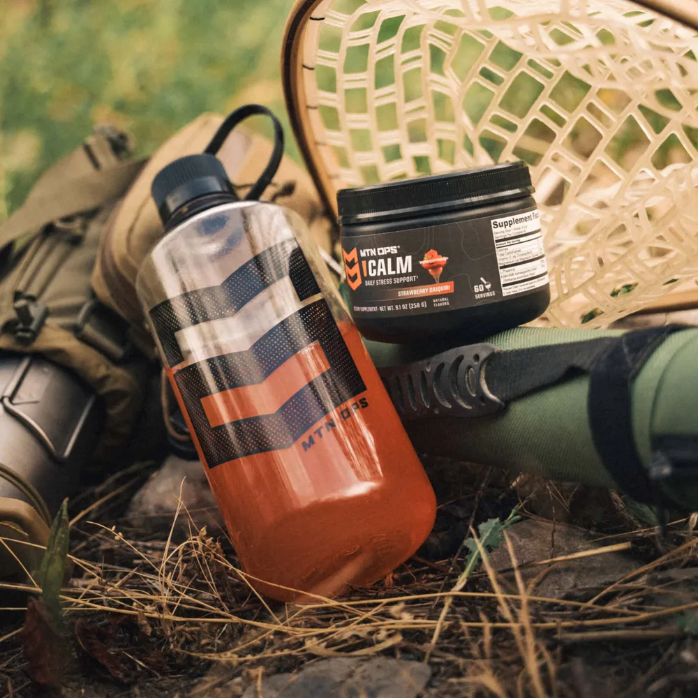 A tub of MTN OPS CALM mixed in a bottle beside camp gear