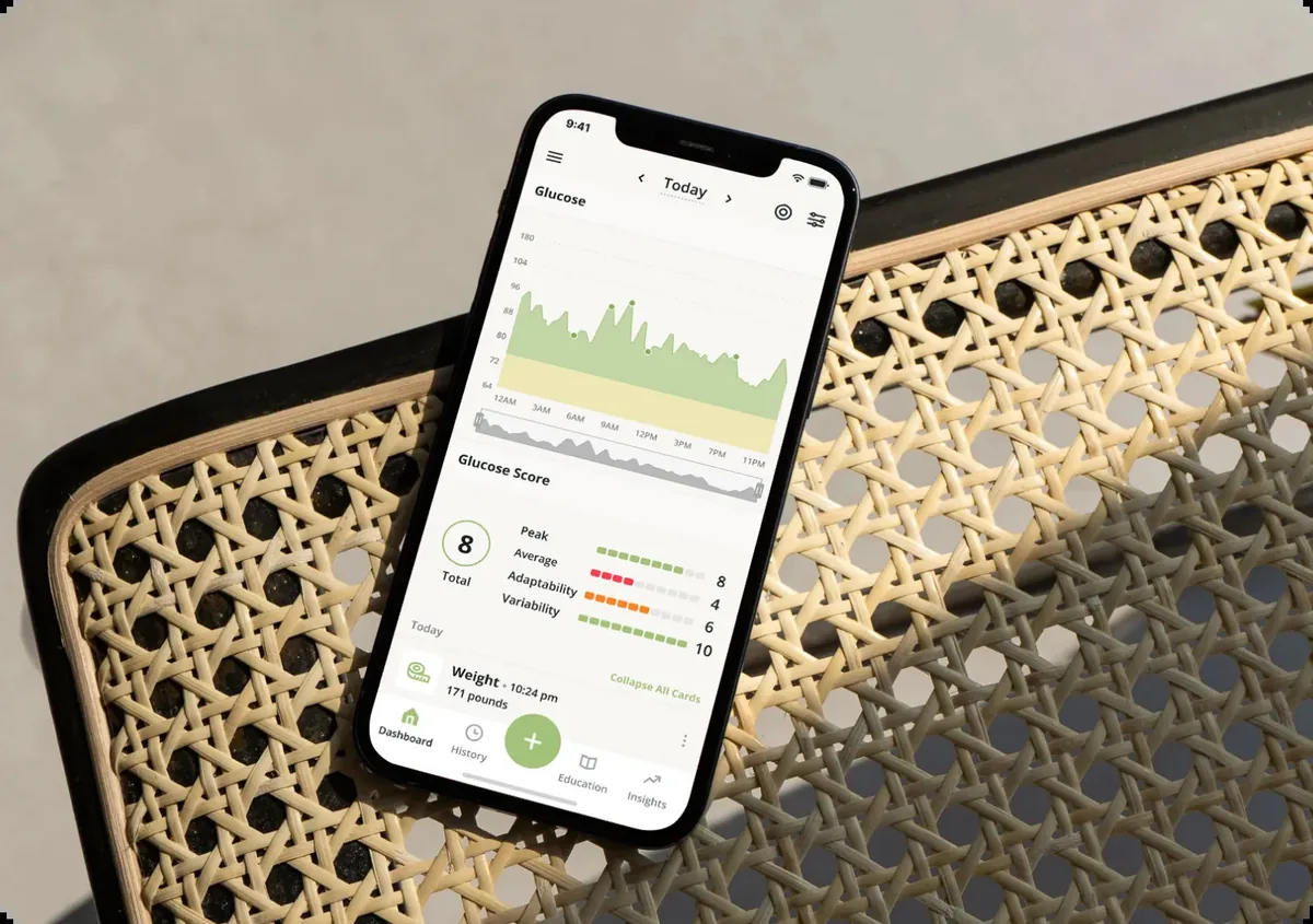 A phone showing the Nutrisense app with one full day of continuous glucose readings drawn as a single jagged line.