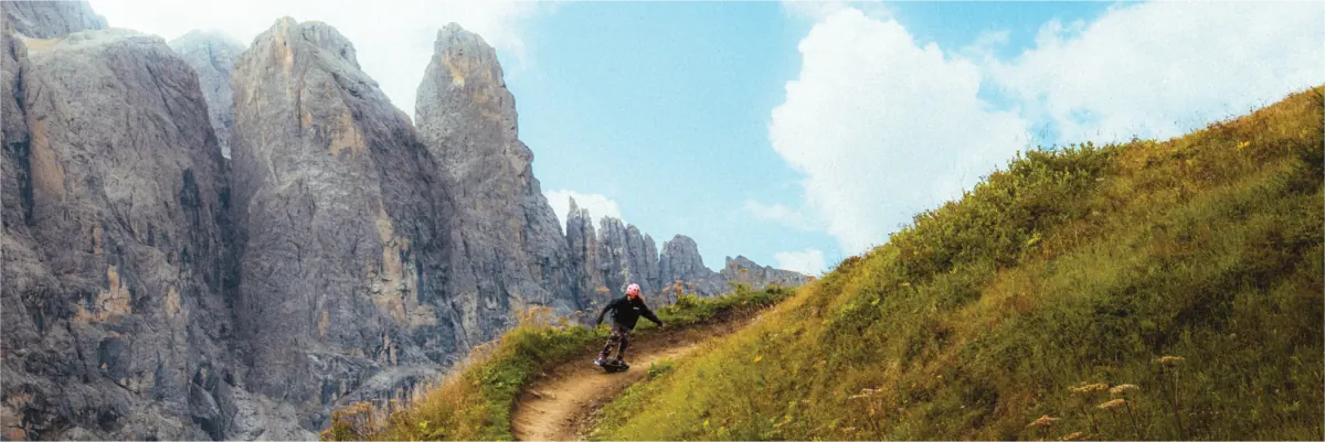 A rider on an alpine trail below the limestone peaks of the Dolomites.