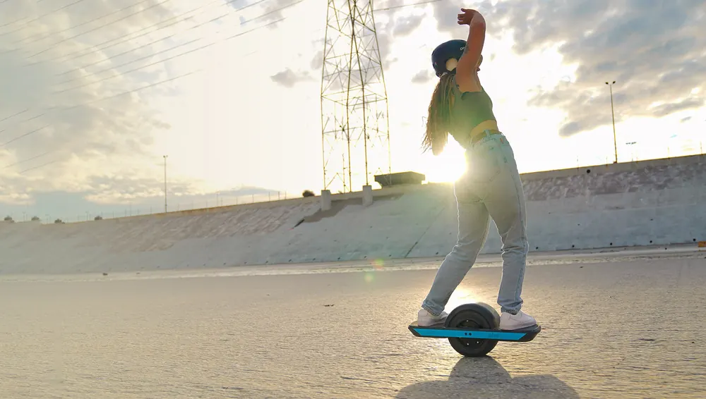 A rider at sunset on a Onewheel.