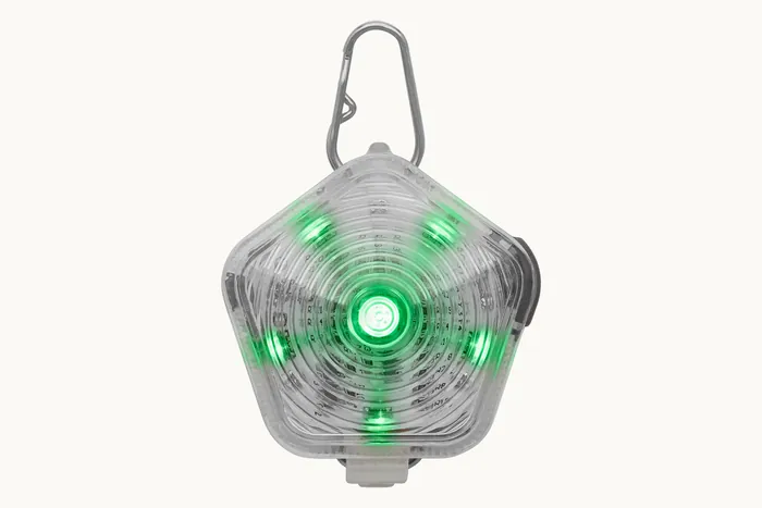 The Beacon safety light glowing green through its translucent shell
