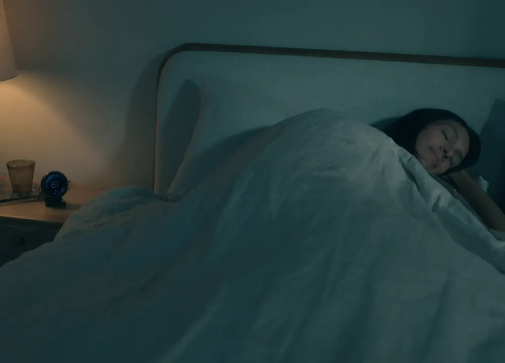 The nightstand remote beside a bed, showing in-bed detection starting the sleep schedule