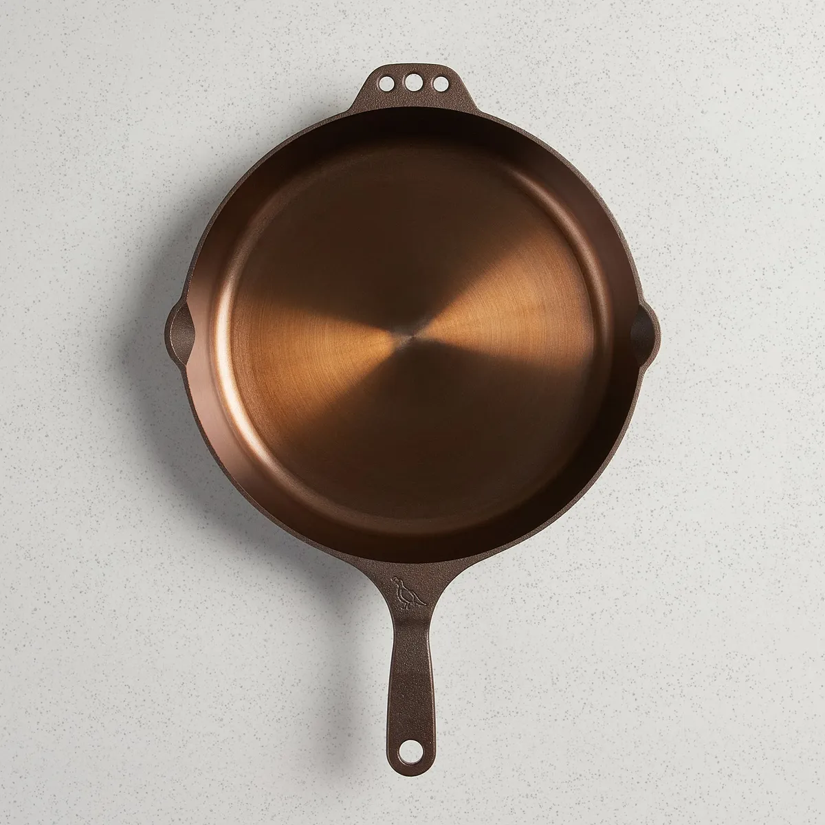 Top down view of a Smithey No. 12 cast iron skillet showing a smooth bronze machined cooking surface.