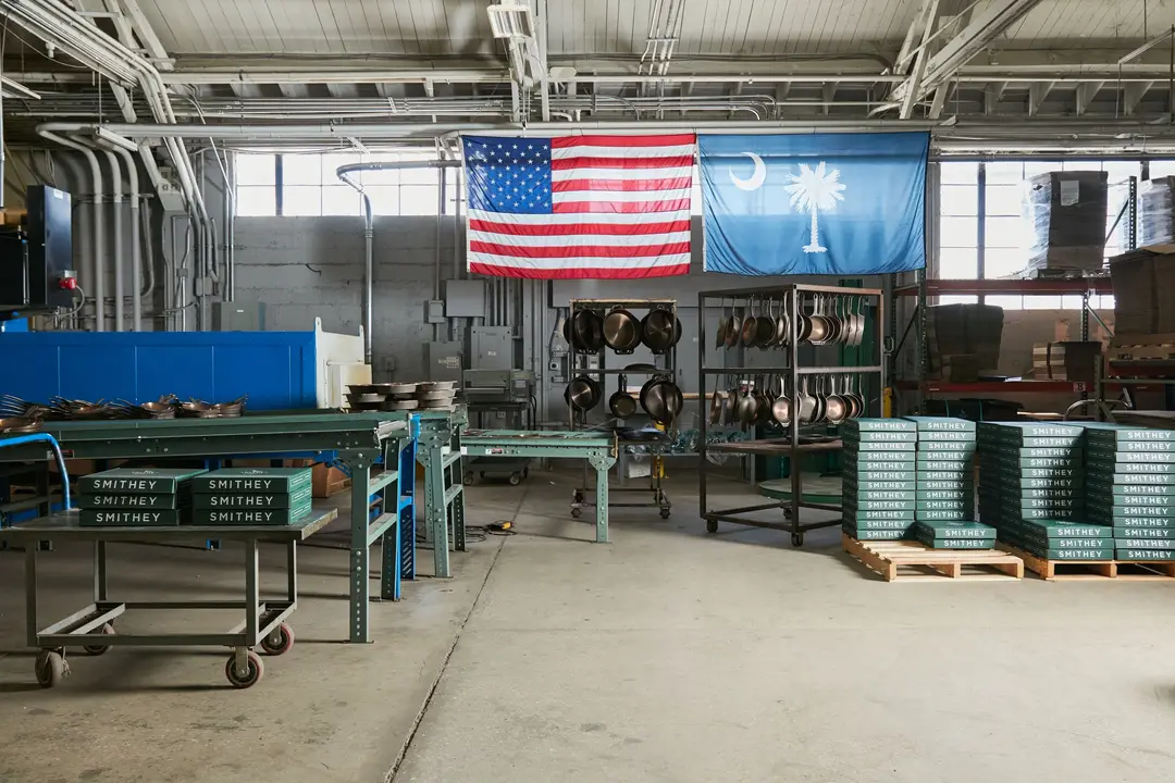The Smithey shop floor in Charleston, South Carolina, with the United States and South Carolina flags hanging over the workbenches.