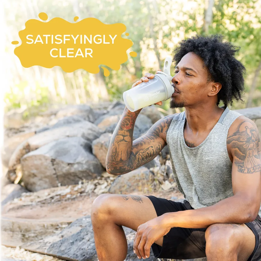 A man drinking Clear Protein from a shaker bottle outdoors