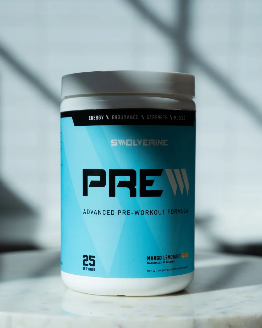 A tub of Swolverine PRE standing on a marble surface in daylight