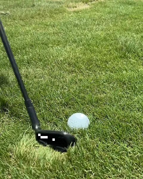 Close view of the QX-1 sole about to move through grass behind a ball