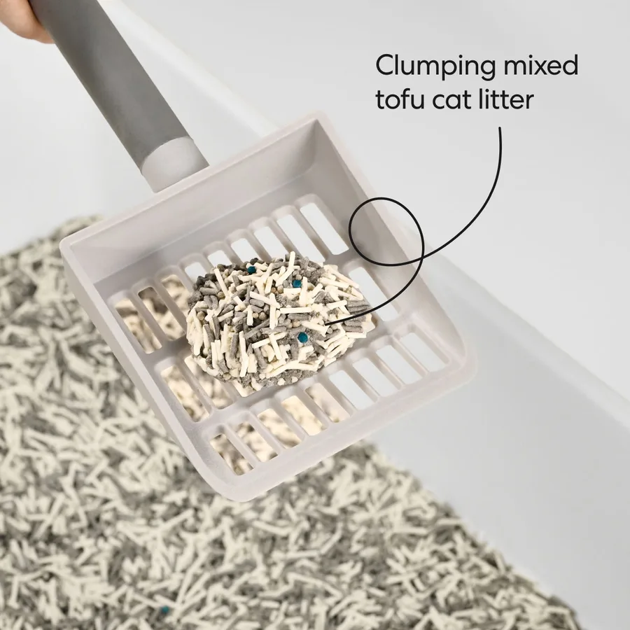 A scoop of OdorStop litter showing pale tofu pellets mixed with darker mineral granules