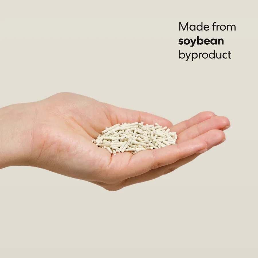 An open palm holding a small heap of pale cylindrical tofu litter pellets