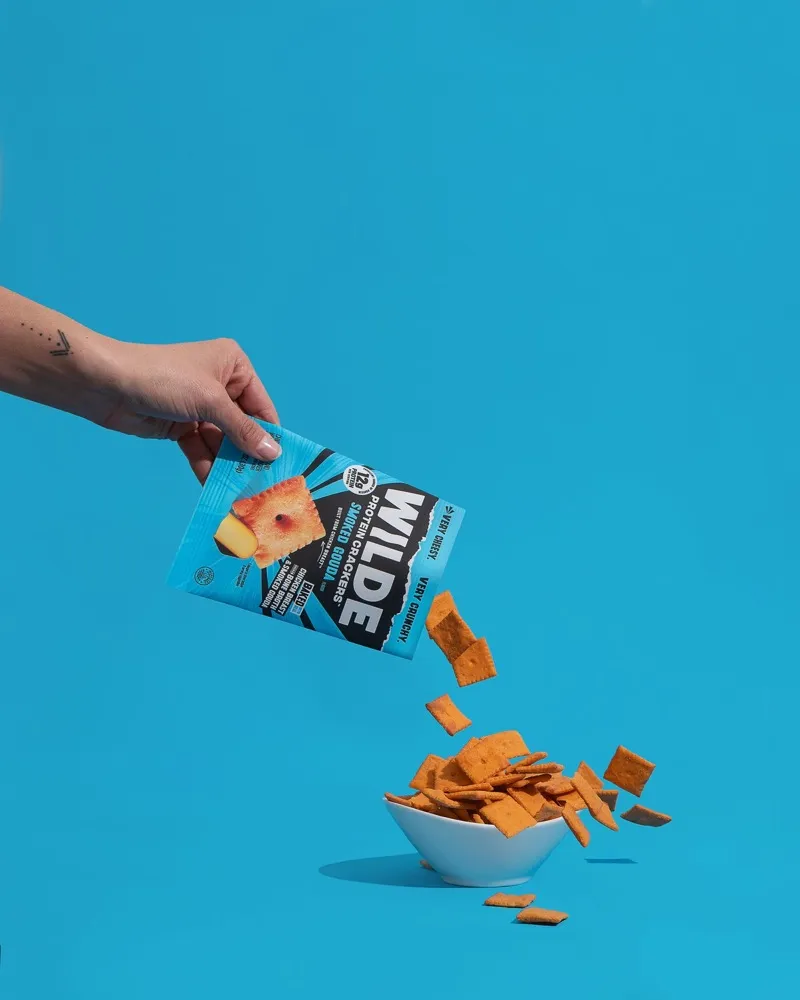 Smoked Gouda WILDE protein crackers pouring out of the bag