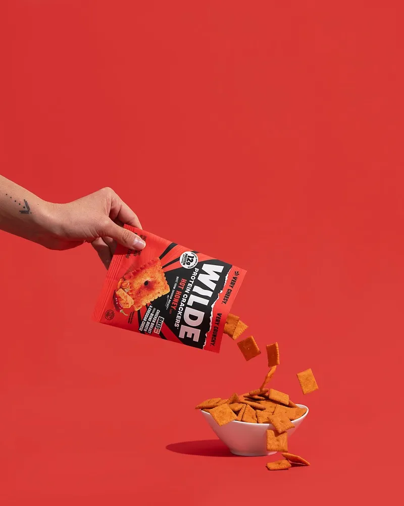 Hot Honey WILDE protein crackers pouring out of the bag
