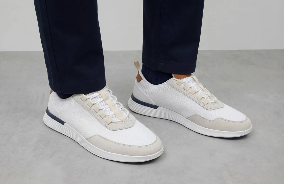 Tailored navy trousers over a white leather Crossover Victory Trainer with a sculpted performance midsole