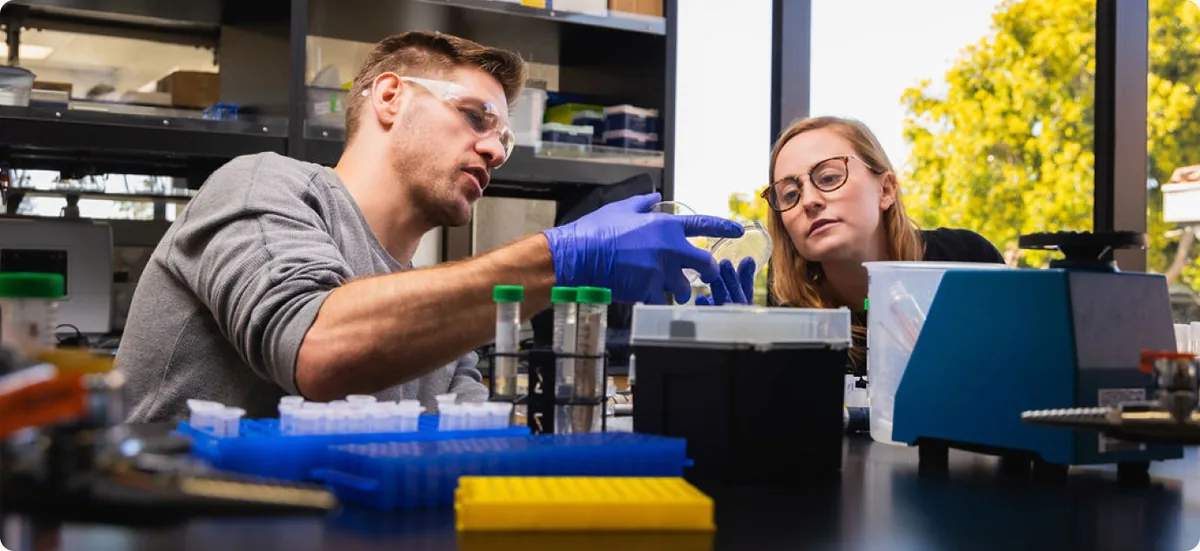Two ZBiotics scientists working with sample tubes at a laboratory bench